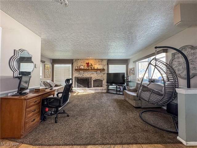 living room with carpet floors, a textured ceiling, and a fireplace