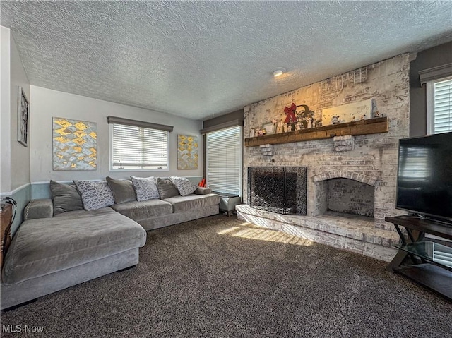 living room featuring carpet floors, a healthy amount of sunlight, a textured ceiling, and a fireplace