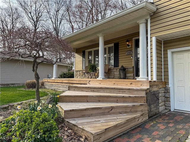 entrance to property with stone siding and covered porch