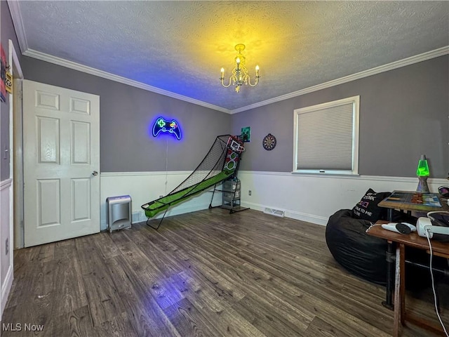 rec room with a textured ceiling, wood finished floors, visible vents, and an inviting chandelier