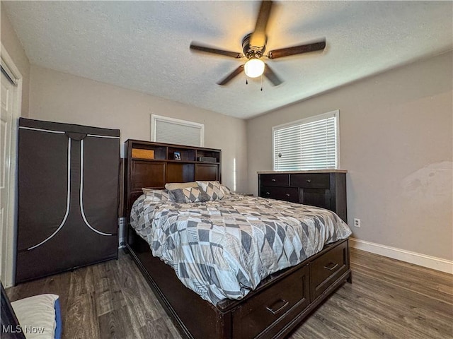 bedroom with baseboards, a ceiling fan, dark wood-style floors, and a textured ceiling
