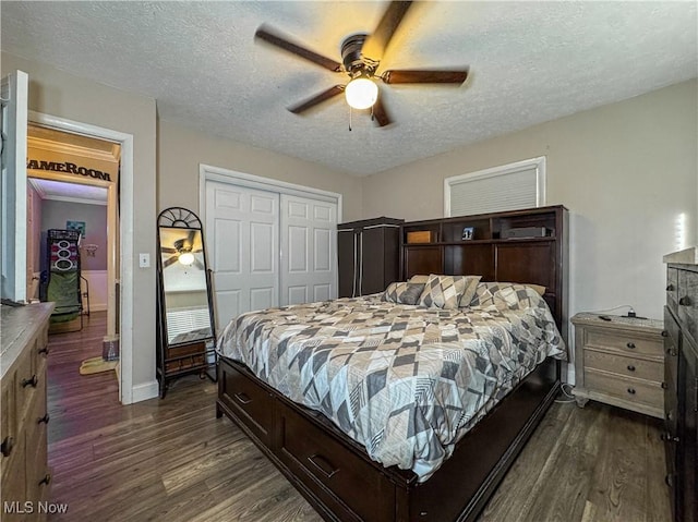bedroom with baseboards, dark wood-style floors, a textured ceiling, and a closet