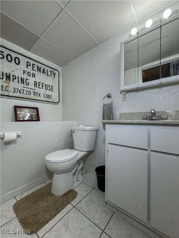 bathroom featuring toilet, vanity, tile patterned floors, and baseboards