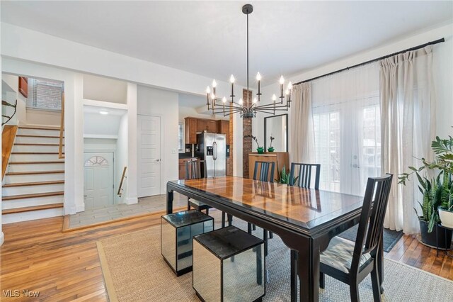 1881 W 65th St, Cleveland, OH 44102 - dining room with a chandelier, light wood finished floors, and stairs