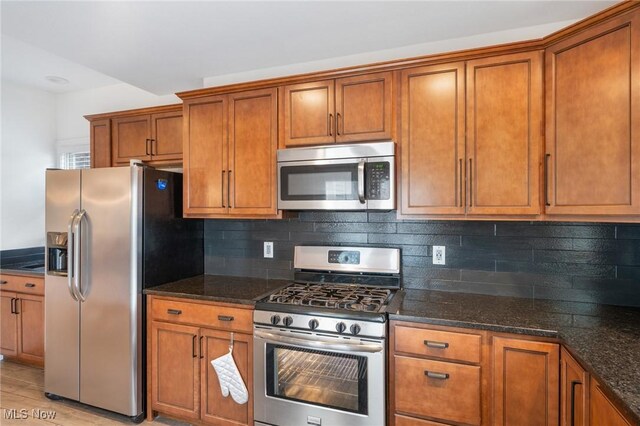 1881 W 65th St, Cleveland, OH 44102 - kitchen with stainless steel appliances, brown cabinets, and dark stone counters