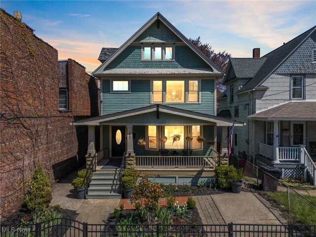 1881 W 65th St, Cleveland, OH 44102 - american foursquare style home featuring a porch, a fenced front yard, stairs, and a gate