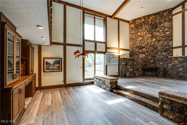 1809 Heritage Cir, Dover, OH 44622 - interior space with high vaulted ceiling, baseboards, a stone fireplace, and light wood-style flooring