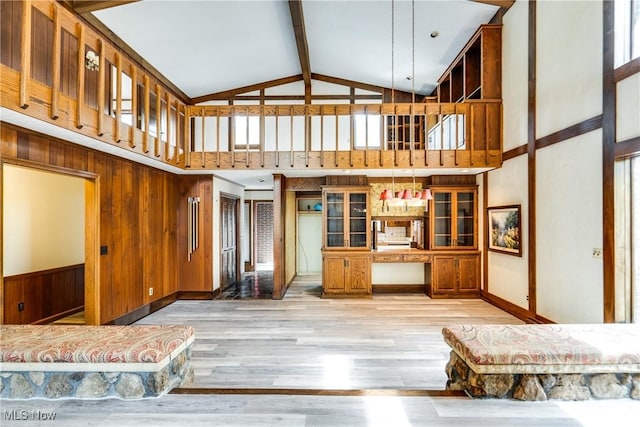 1809 Heritage Cir, Dover, OH 44622 - unfurnished living room featuring wooden walls, beam ceiling, light wood finished floors, and high vaulted ceiling