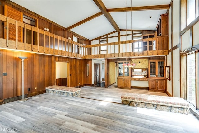 1809 Heritage Cir, Dover, OH 44622 - unfurnished living room with wooden walls, beam ceiling, wood finished floors, and high vaulted ceiling