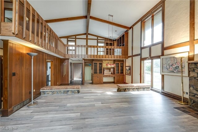 1809 Heritage Cir, Dover, OH 44622 - unfurnished living room featuring beamed ceiling, wood finished floors, high vaulted ceiling, and wood walls