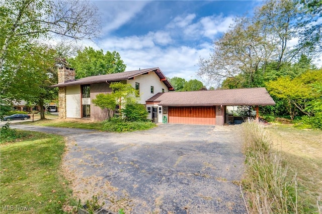 1809 Heritage Cir, Dover, OH 44622 - exterior space with a garage, a carport, a chimney, and aphalt driveway