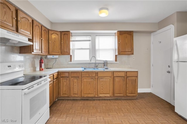 3533 Carlyle Ave, Cleveland, OH 44109 - kitchen with brown cabinets, under cabinet range hood, a sink, and white appliances