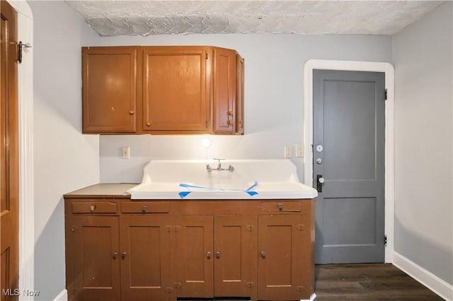 3533 Carlyle Ave, Cleveland, OH 44109 - kitchen featuring light countertops, baseboards, dark wood-style floors, and brown cabinets