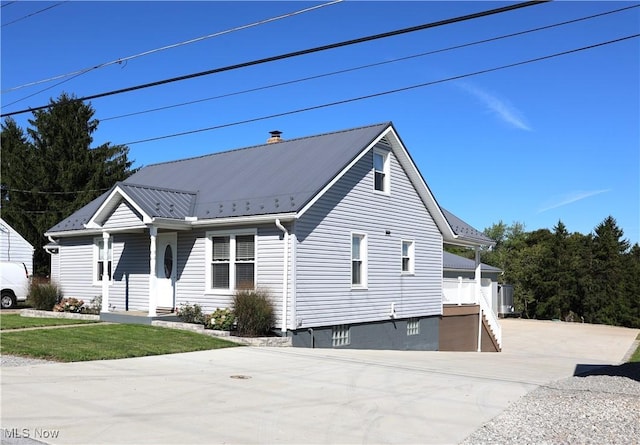 view of front of home featuring a chimney and metal roof