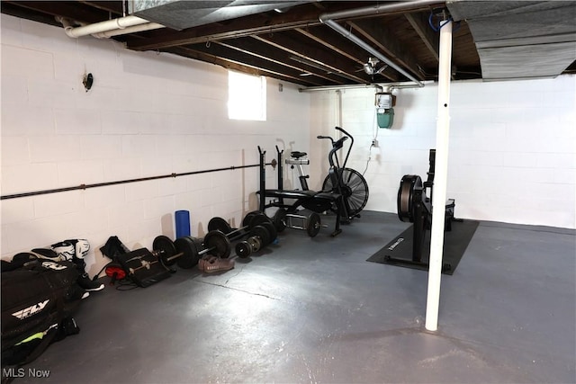 exercise room featuring concrete block wall