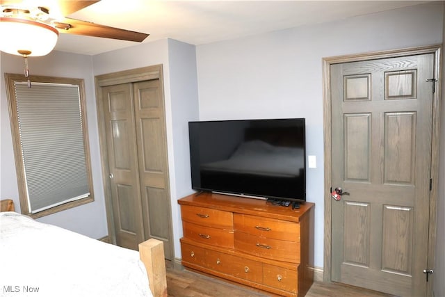 bedroom featuring a closet, light wood-style floors, and ceiling fan