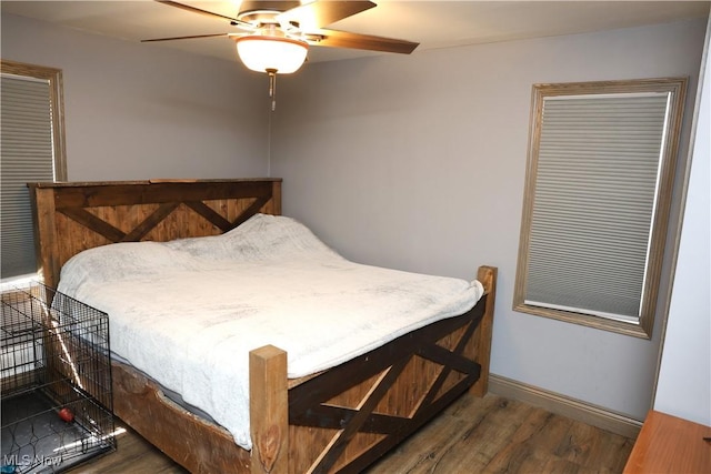 bedroom featuring wood finished floors, a ceiling fan, and baseboards