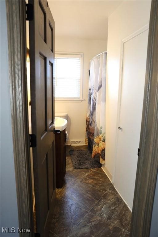 full bathroom with curtained shower, baseboards, visible vents, and vanity