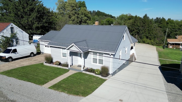 view of front facade featuring a garage, driveway, a chimney, and a front lawn