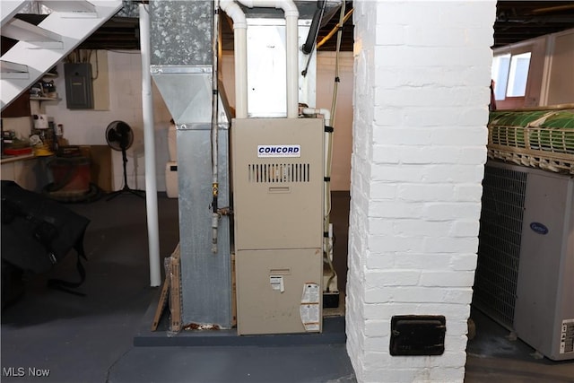 utility room featuring heating unit and electric panel