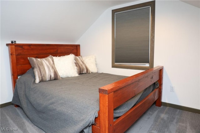 bedroom with vaulted ceiling, baseboards, and carpet