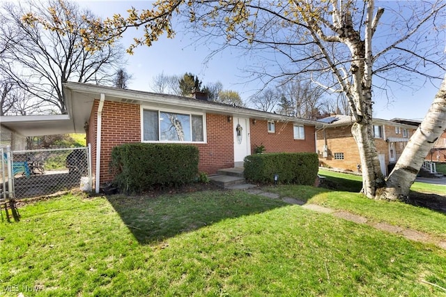view of front facade with a chimney, brick siding, fence, and a front yard