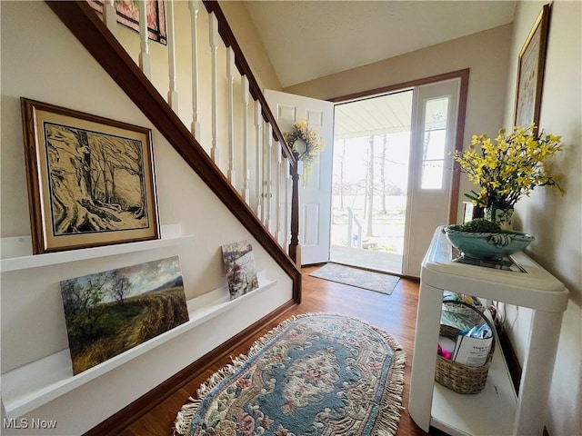 entryway with lofted ceiling, wood finished floors, and stairway