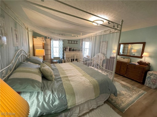 bedroom with wood finished floors and a textured ceiling
