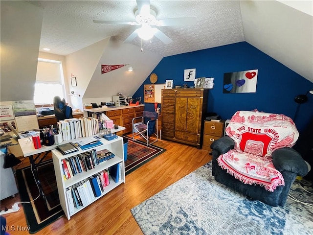 office featuring lofted ceiling, a ceiling fan, a textured ceiling, and light wood finished floors