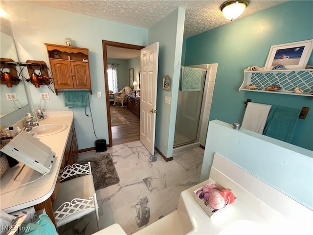 bathroom with marble finish floor, vanity, baseboards, a stall shower, and ensuite bathroom