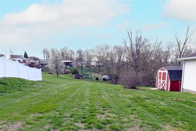 view of yard featuring fence, an outbuilding, and a storage unit