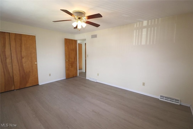 unfurnished bedroom with baseboards, wood finished floors, and visible vents