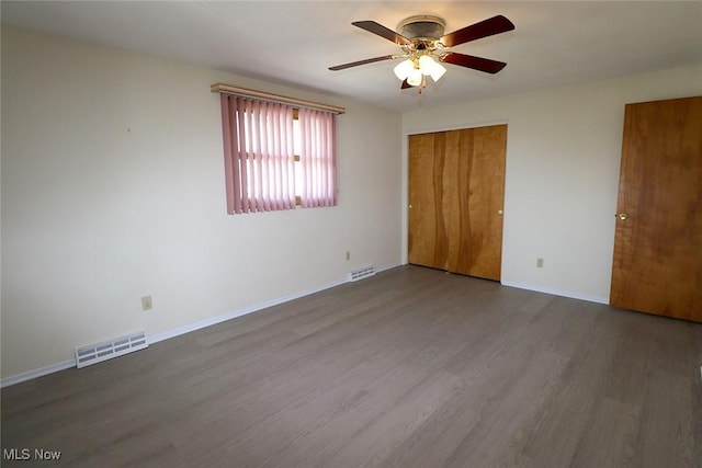 unfurnished bedroom featuring wood finished floors, visible vents, baseboards, and ceiling fan