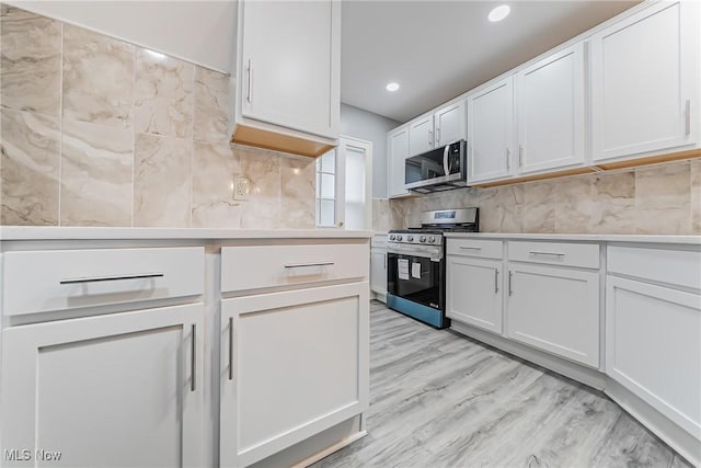 kitchen with light countertops, appliances with stainless steel finishes, and white cabinetry