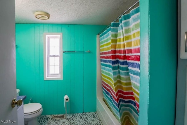 full bath with a textured ceiling and toilet