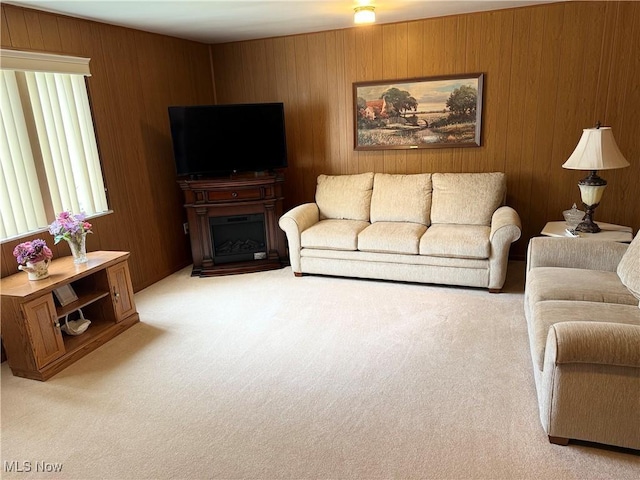 carpeted living area featuring wooden walls and a fireplace
