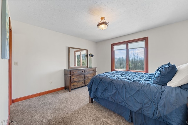 carpeted bedroom with baseboards and a textured ceiling