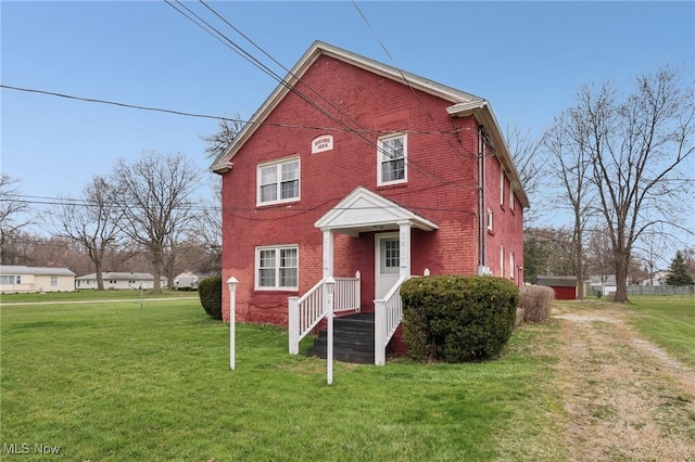 traditional-style house with a front lawn and brick siding