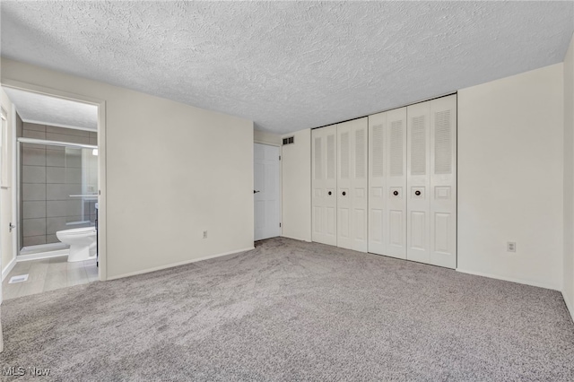unfurnished bedroom featuring carpet floors, a textured ceiling, and baseboards