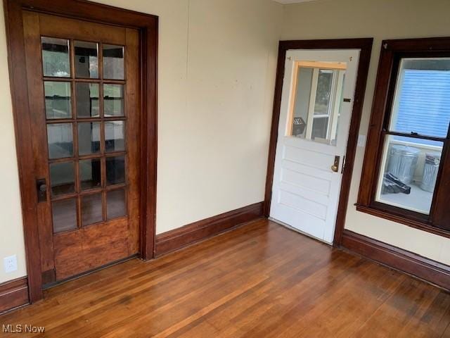 doorway featuring wood finished floors and baseboards