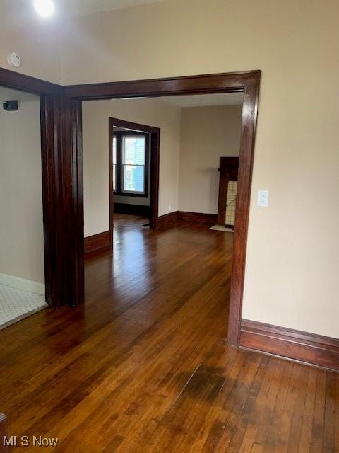 unfurnished room featuring wood-type flooring and baseboards