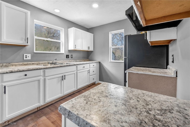 kitchen with recessed lighting, wood finished floors, white cabinetry, and a sink