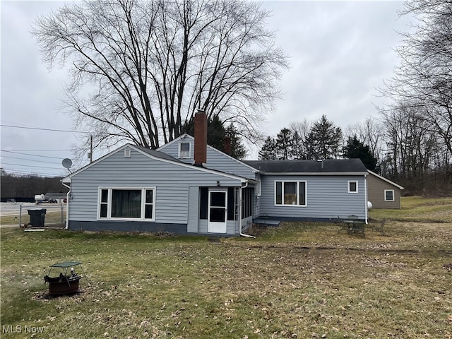 rear view of house with a yard and a chimney