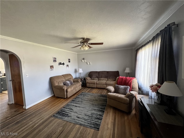 living area with arched walkways, a textured ceiling, baseboards, a ceiling fan, and wood finished floors
