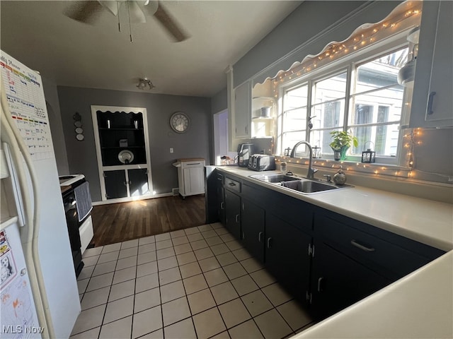 kitchen with white fridge with ice dispenser, a ceiling fan, light countertops, and a sink
