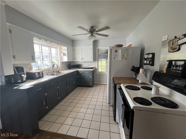 kitchen with white range with electric cooktop, a healthy amount of sunlight, a ceiling fan, and a sink