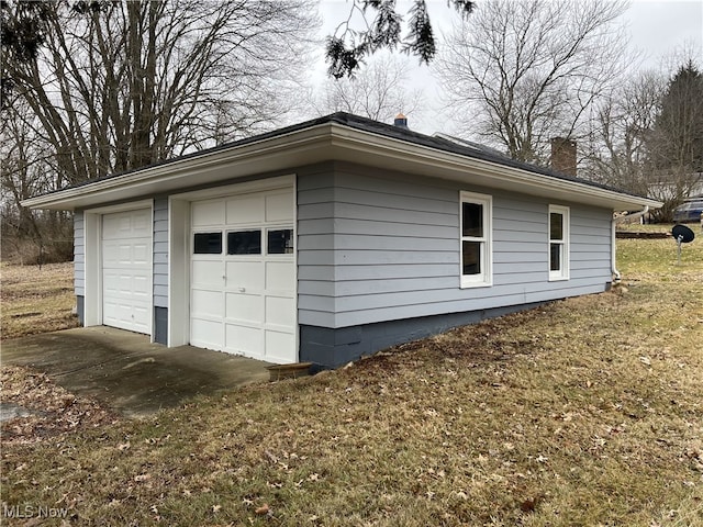 view of property exterior with a chimney, an outdoor structure, and a detached garage
