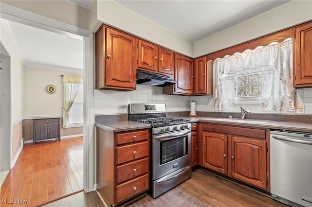 1332 Springbrook Dr, Mansfield, OH 44906 - kitchen with stainless steel appliances, a sink, dark wood finished floors, dark countertops, and under cabinet range hood