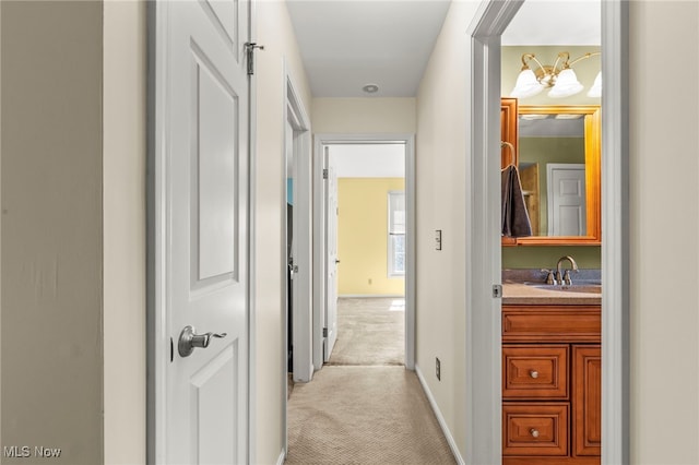 1332 Springbrook Dr, Mansfield, OH 44906 - hall with light carpet, baseboards, a sink, and a chandelier