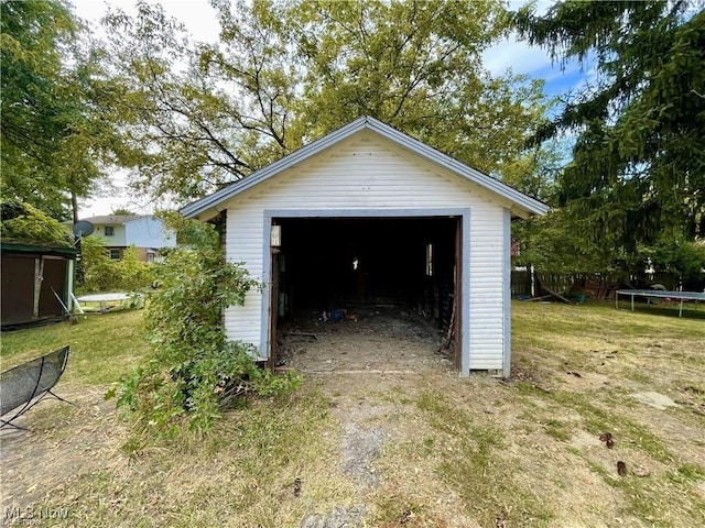 974 Madison Ave, Alliance, OH 44601 - detached garage featuring a trampoline, driveway, and fence